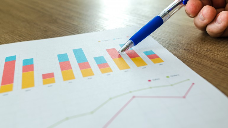 Man showing business graph on wooden table